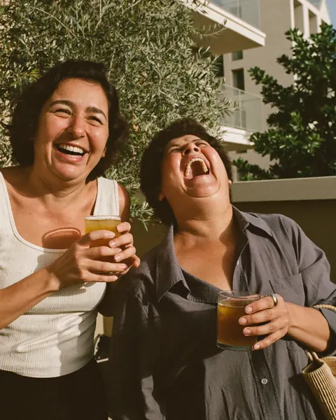 Dos amigas se ríen fuerte en una terraza